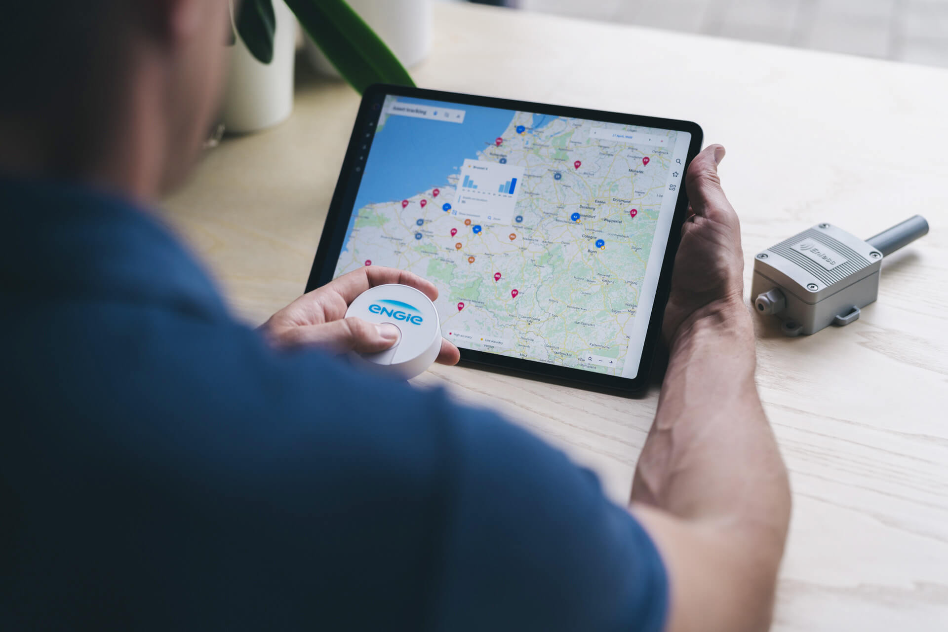 A connected sensor beside a tablet showing its fleet on a map