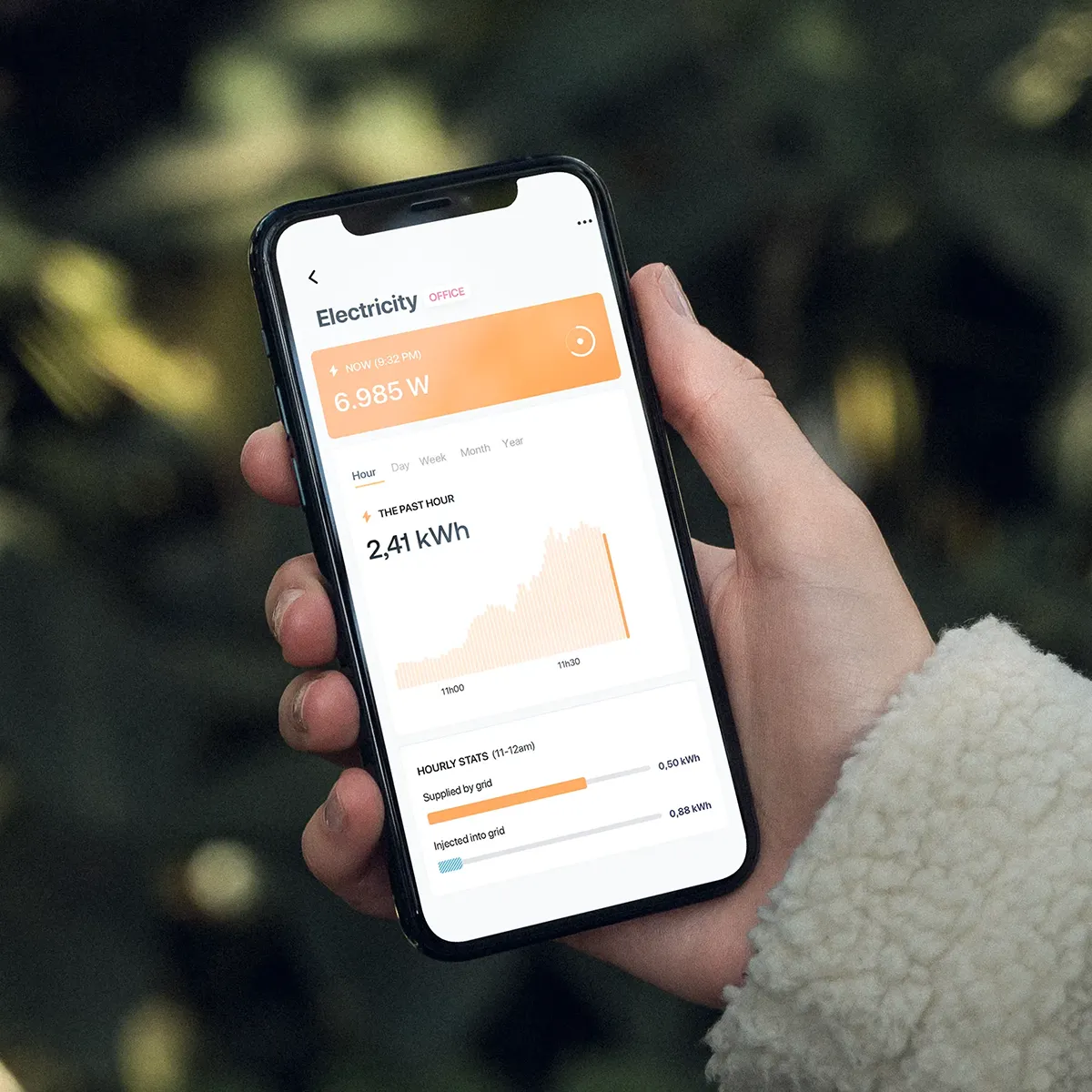 The Smartbirds app in the hands of a consumer checking their current electricity usage and viewing the history of the past hour.