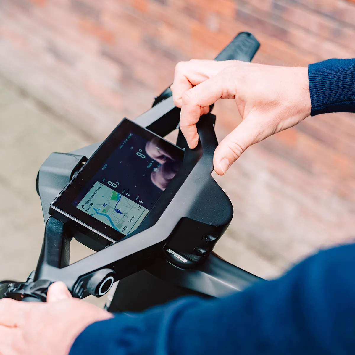 The view of the Specter speed pedelec steering wheel, showing the digital HUD with the turn by turn navigation, speed and weather.