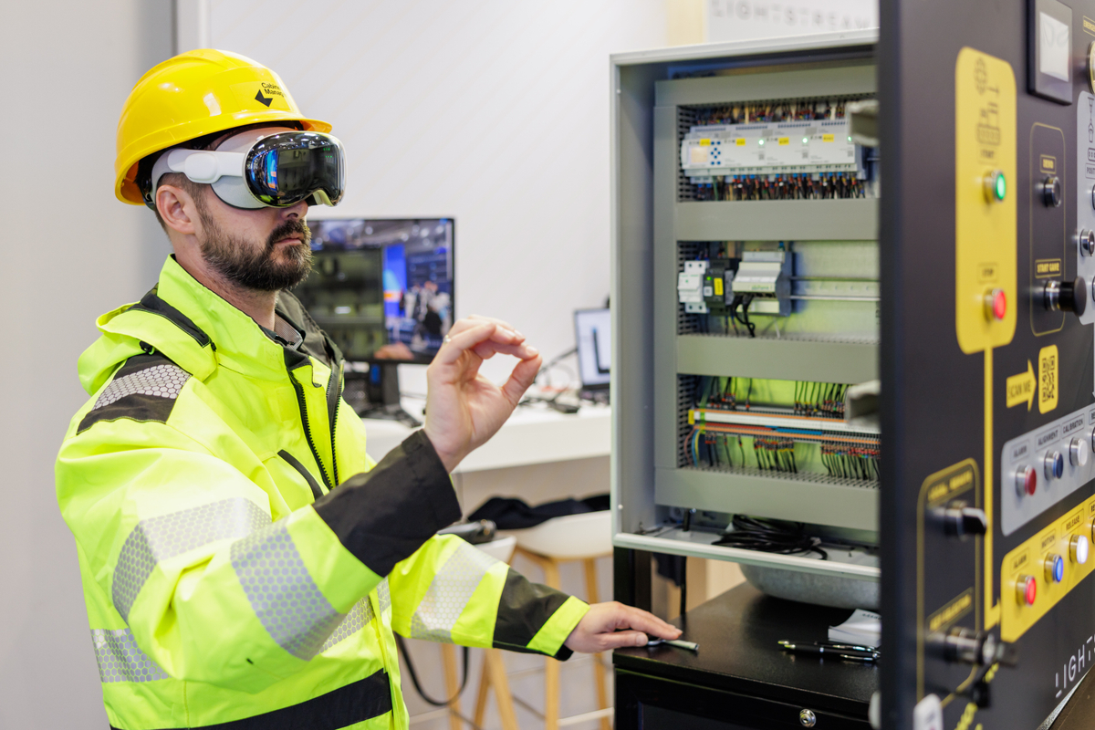 A picture of a technician working on an electrical circuit board with the apple vision pro, using Cabinet manager from Lightstream.