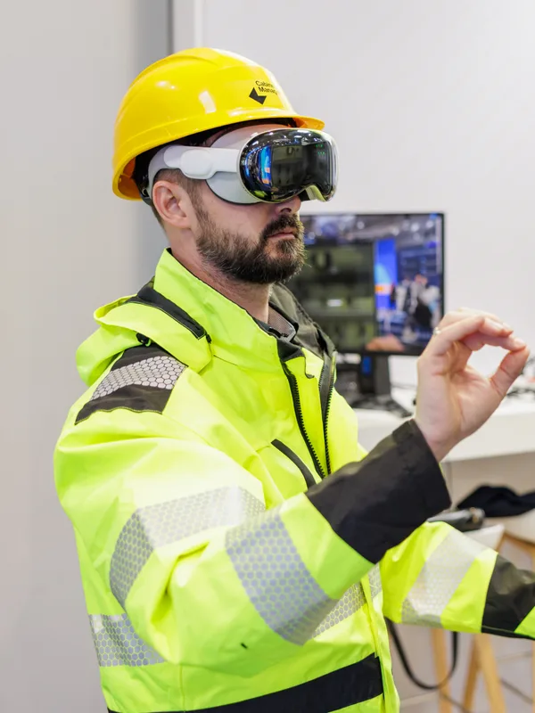A technician in an AR headset working at an electrical control cabinet